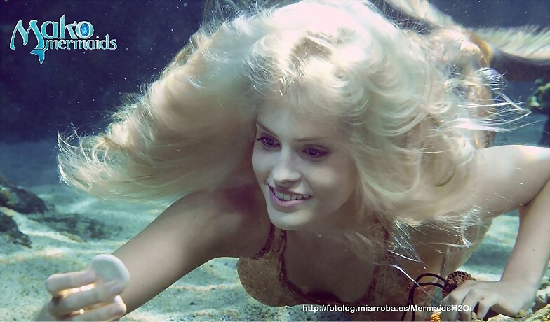Sirena en el mar cogiendo conchas